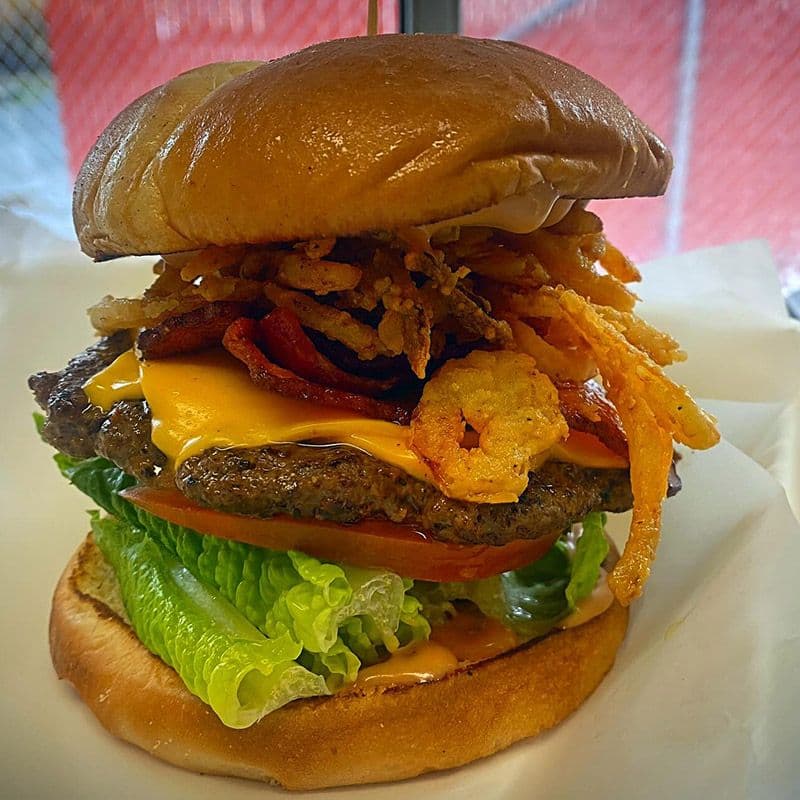 Mega Melt stacked burger with lettuce, tomato, patty, cheese, shrimp, and crispy onions